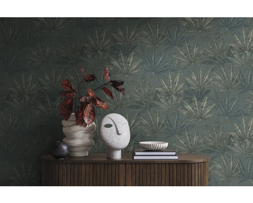 Scen med en byrå, dekoration och en tapet med växtmönster.