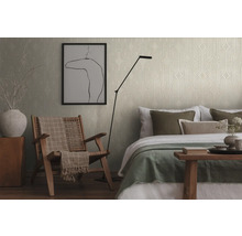 Sovrum med mönstrad tapet, fåtölj och säng