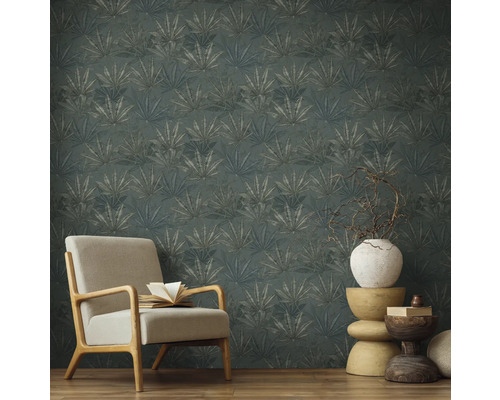 Miljöbild med fåtölj och en vägg med mönstrad tapet med växtmotiv