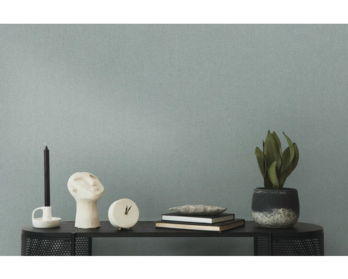 Dekorativt arrangemang med ljus, skulptur, klocka, böcker och krukväxt på en hylla