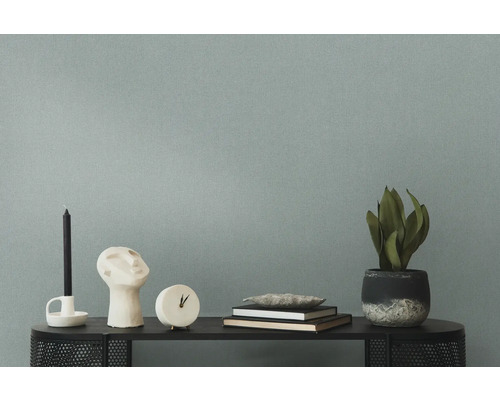 Dekorativa föremål som ljus, skulptur, klocka, böcker och krukväxt på ett bord