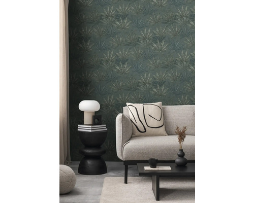 Vardagsrum med mönstrad tapet, soffa och sidobord