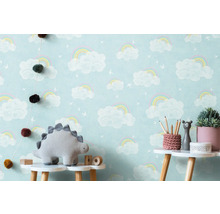 Barnrum med molnregnbågstapet, dinosaurieplysch och dekoration på ett bord