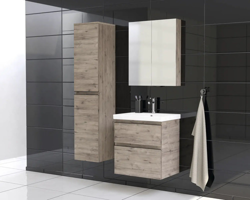 Badrum med tvättställ, spegelskåp och högskåp i trädekor framför mörk kakelvägg