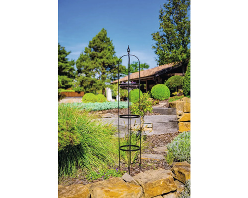 Planteringshjälp i metall med tre hyllor i trädgården.