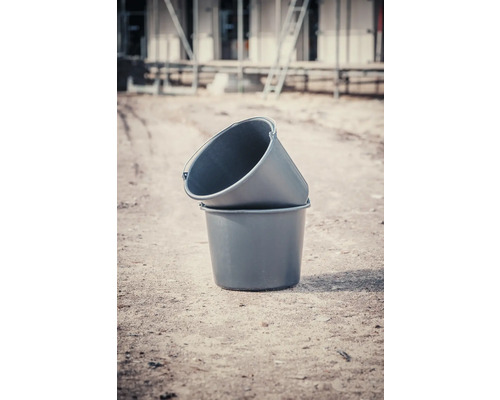 Två murbinkar i plast staplade på varandra på en byggarbetsplats.