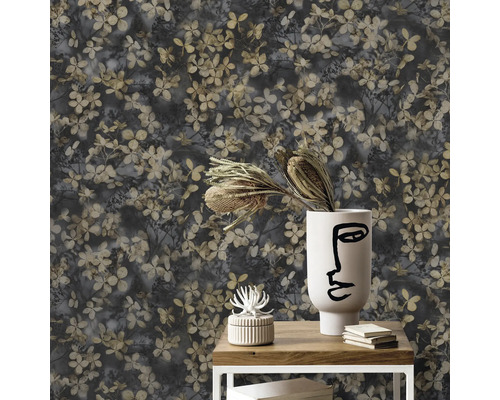 Närbild av en vägg med ett blommigt tapetmönster, som är arrangerat på ett litet bord med dekoration.