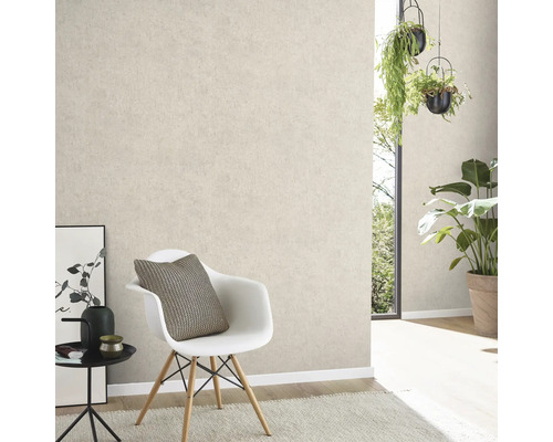 Ljust vardagsrum med ljusbeige mönstrad tapet, stol, bord och växter