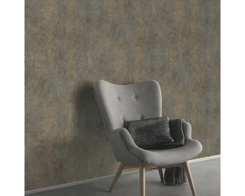 Väggdekoration med grå non-woven tapet bredvid en fåtölj.
