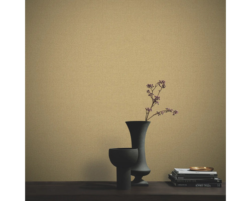 Närbild av en strukturerad tapet med vaser och böcker på ett bord