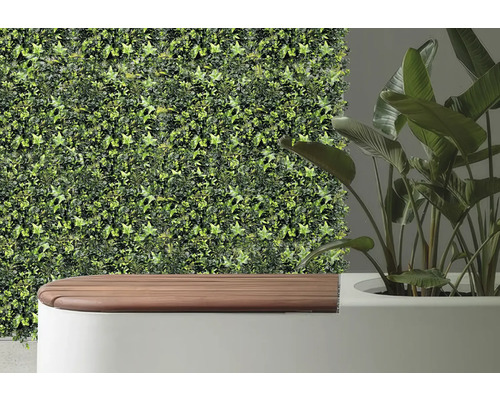 Dekorativ väggbeklädnad med konstgjord murgröna bredvid en bänk och en krukväxt.