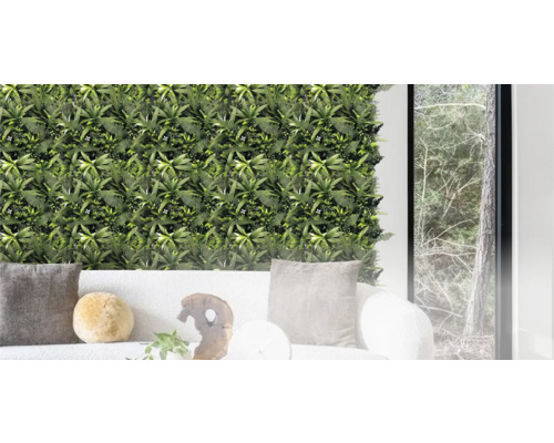 Gröna väggpaneler med växter och ormbunkar bakom en soffa
