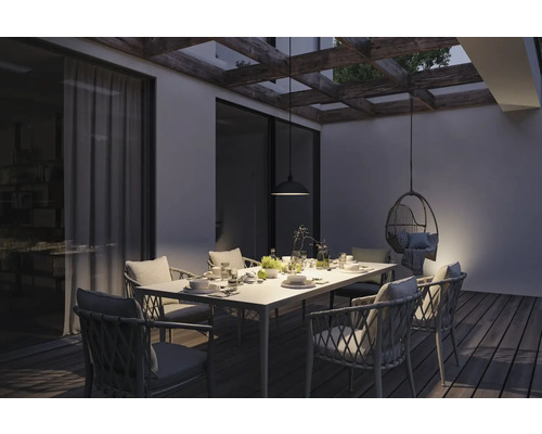 Terrass med matbord, stolar, hänglampa och hängfåtölj