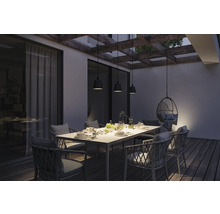 Terrass med matbord, stolar och hänglampor under en pergola