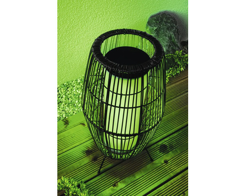 Dekorativ svart golvlampa med rottinglampskärm för utomhusbruk.