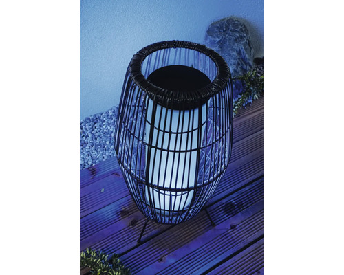 Dekorativ trädgårdslampa med rottingutseende och belysning för utomhusbruk.