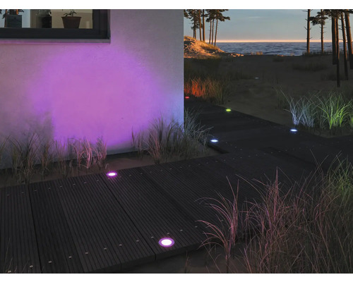 Terrass med färgade infällda markspotlights, utomhusområde på natten