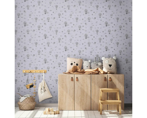 Barnrum med tapet med luftballongmönster, träskåp och leksaksdekoration