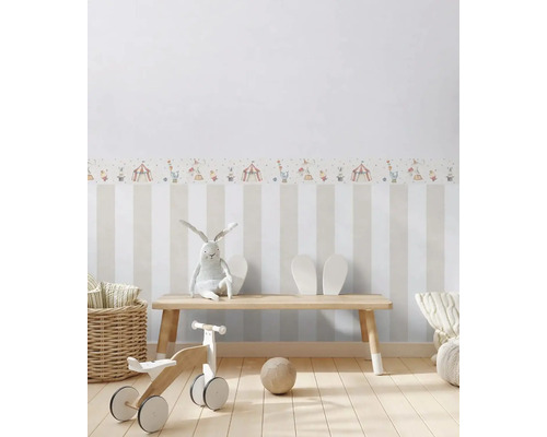 Barnrum med randig tapet och cirkusmotivbård, med träbänk, leksaker och dekoration