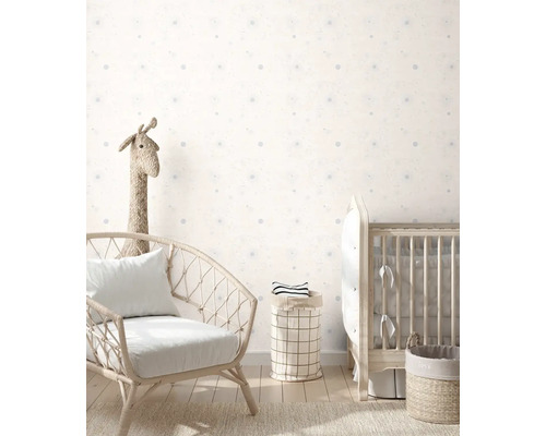 Barnrum med fåtölj, spjälsäng och förvaringskorgar mot en vägg med prickigt mönster.