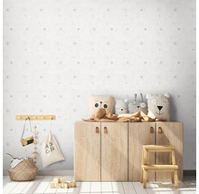 Barnrum med ljust mönstrad tapet, träskåp och dekorationer.