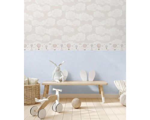 Barnrum med tapet med moln- och ballongmönster, träbänk, tygkanin och träleksaker