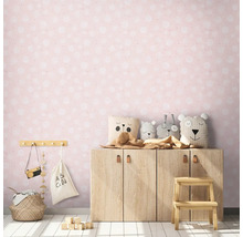 Barnvänligt rum med rosa tapet, träskåp och gosedjur.