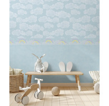 Barnrum med tapet med moln- och regnbågsmönster, bänk, leksaker och dekorationer för en ljus och vänlig atmosfär.