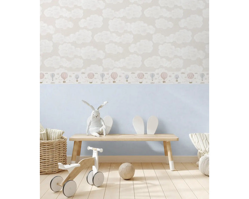 Barnrum med moln- och luftballongstapeter, träbänk och leksaker