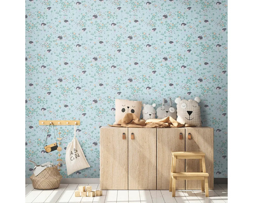 Barnrum med mönstrad tapet, träbyrå och dekorativa föremål