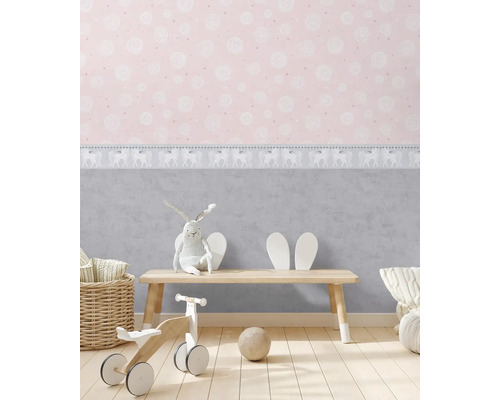 Barnrum med mönstrad tapet, leksaker och trämöbler för en ljus och vänlig atmosfär.