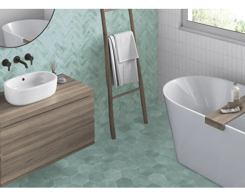 Badrum med handfat, badkar, stege och vägg- och golvplattor i olika former