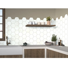 Köksscen med vita, hexagonala plattor på väggen, kompletterat med en trähylla och en arbetsbänk