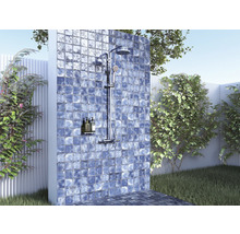 Utomhusdusch med kakelvägg i trädgårdsmiljö