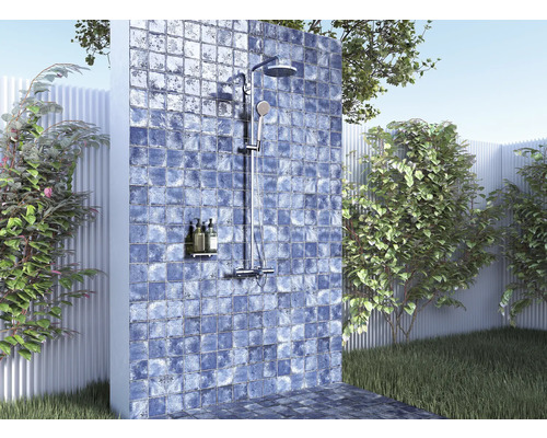 Utomhusdusch med kakelvägg i trädgårdsmiljö