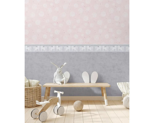 Barnrum med rosa tapet, leksaker och en liten träbänk.