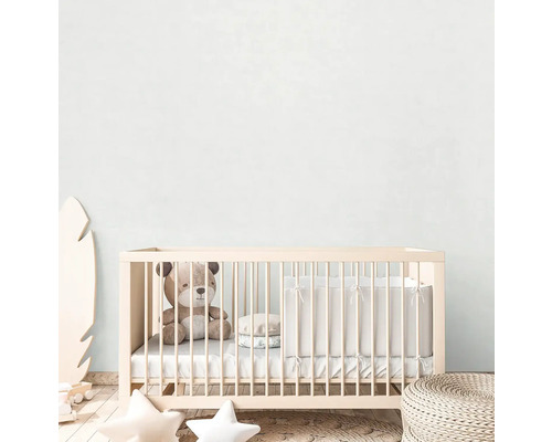 Ett barnrum med en spjälsäng, en teddybjörn och dekorationer.