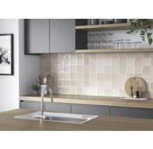 Köksscen med diskho, blandare och kvadratiska väggplattor