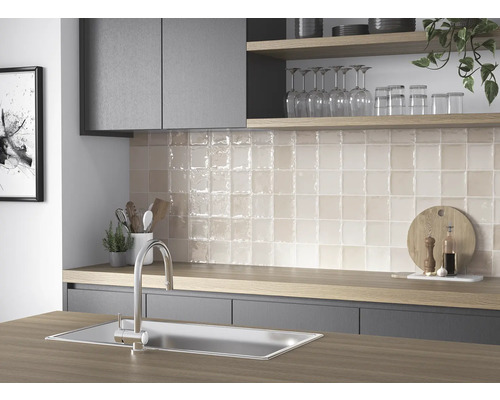 Köksscen med diskho, blandare och kvadratiska väggplattor