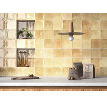 Köksvägg kaklad med fyrkantiga plattor, hyllor, dekorationer och matvaror