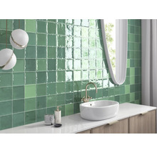 Badrum med grönt kakel, handfat och spegel