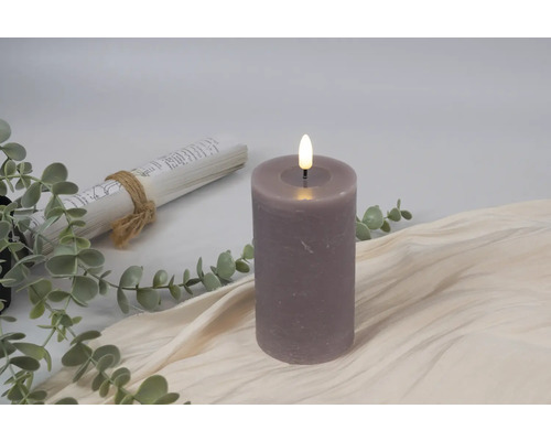 Dekorativt LED-ljus bredvid bokrulle och eukalyptusgrenar