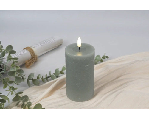 Dekorativt LED-blockljus med växter och en skriftrulle på beige tyg