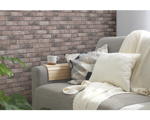 Mysigt vardagsrum med tapet med tegelstensmönster, soffa, kuddar och sidobord