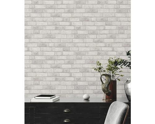 Väggdekoration med tapet i stenlook ovanför byrå