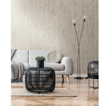 Vardagsrum med beige strukturtapet, soffa och svart rottingbord
