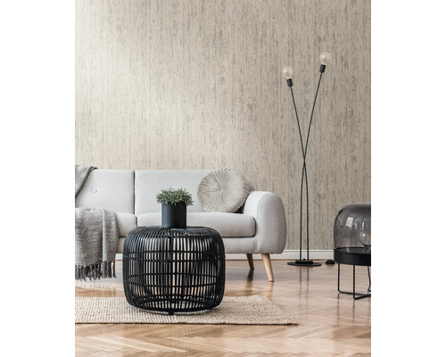 Vardagsrum med beige strukturtapet, soffa och svart rottingbord