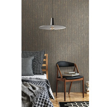 Sovrum med säng, stol, lampa och mönstrad tapet