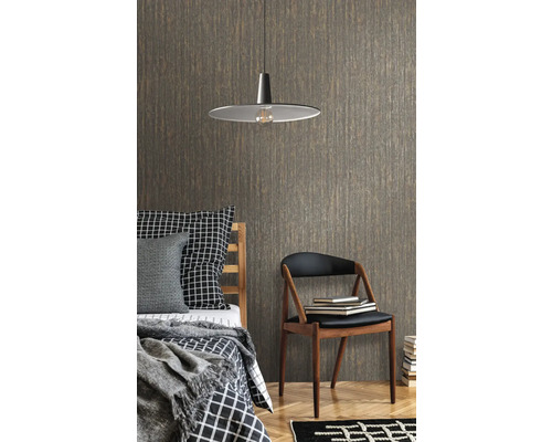 Sovrum med säng, stol, lampa och mönstrad tapet