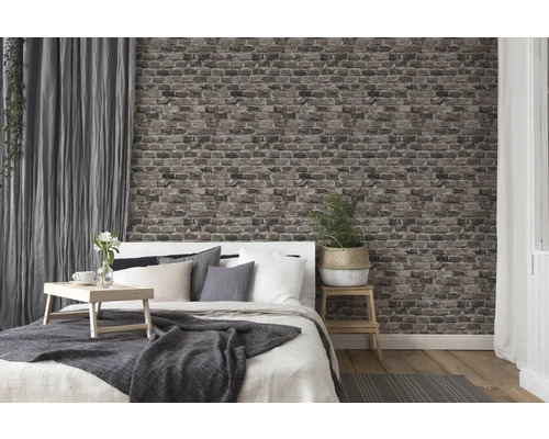 Sovrum med säng, sängbord, gardiner och tapeter i tegelstensdesign för en mysig atmosfär